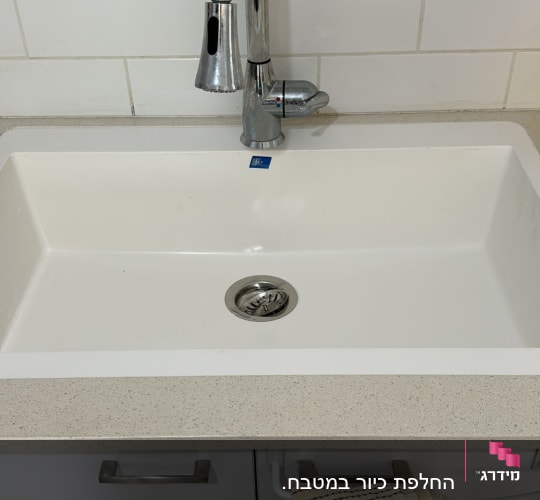 כיור עם משטח שיש בהיר וברז כרום מבריק